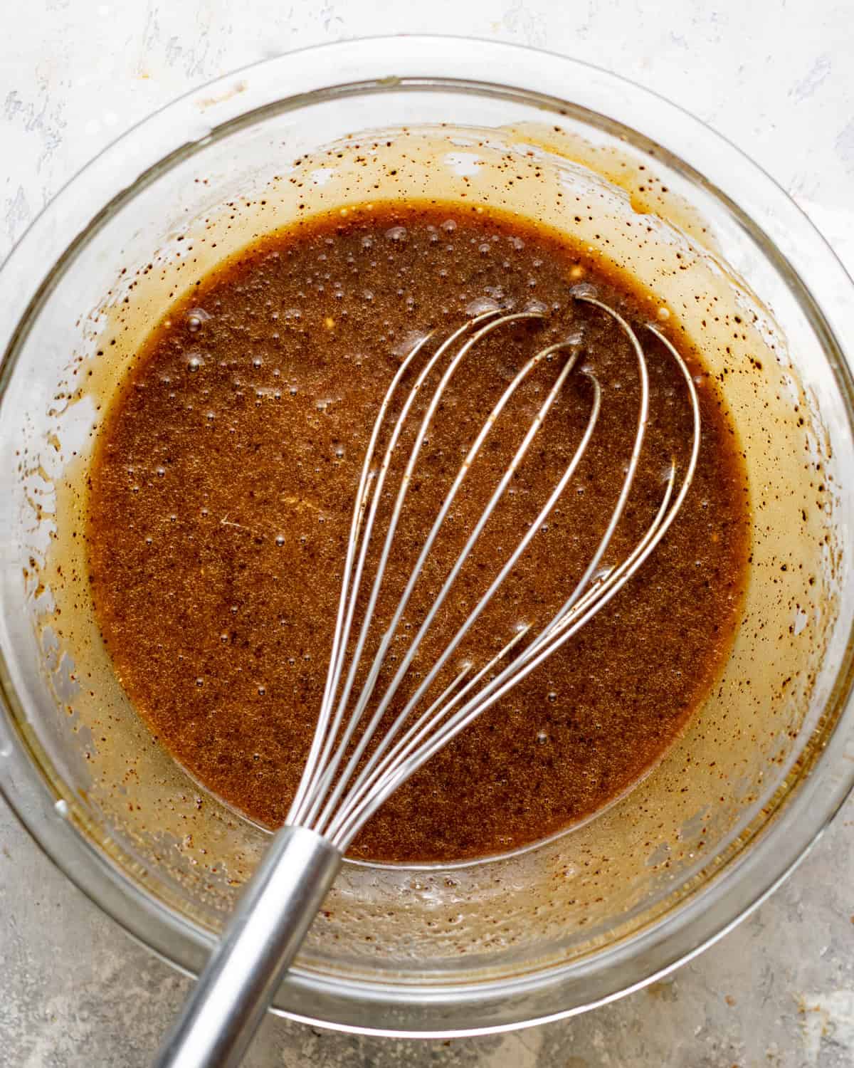browned butter, sugar, eggs, oil, and sour cream whisked together in a bowl. 