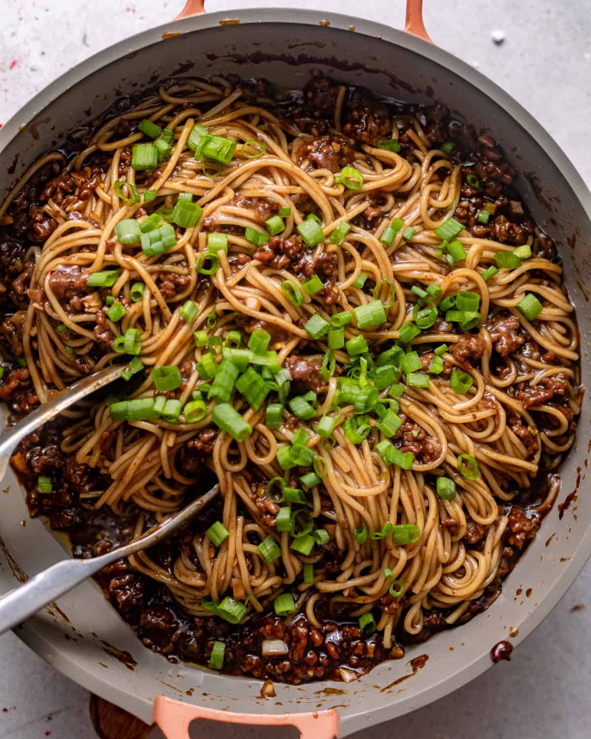 noodles added to the ground beef mixture with scallions and sesame seeds on top. 