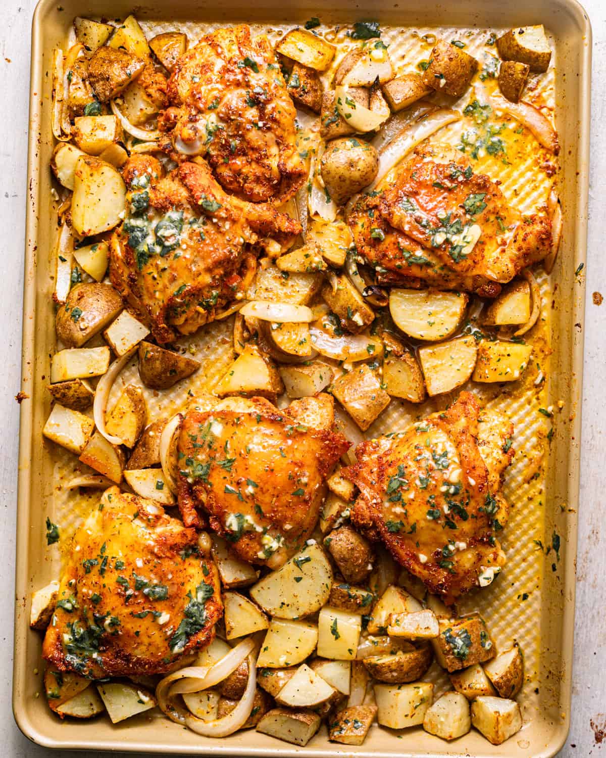 chicken thighs, potatoes, and onions covered in a lemon and garlic dijon dressing.