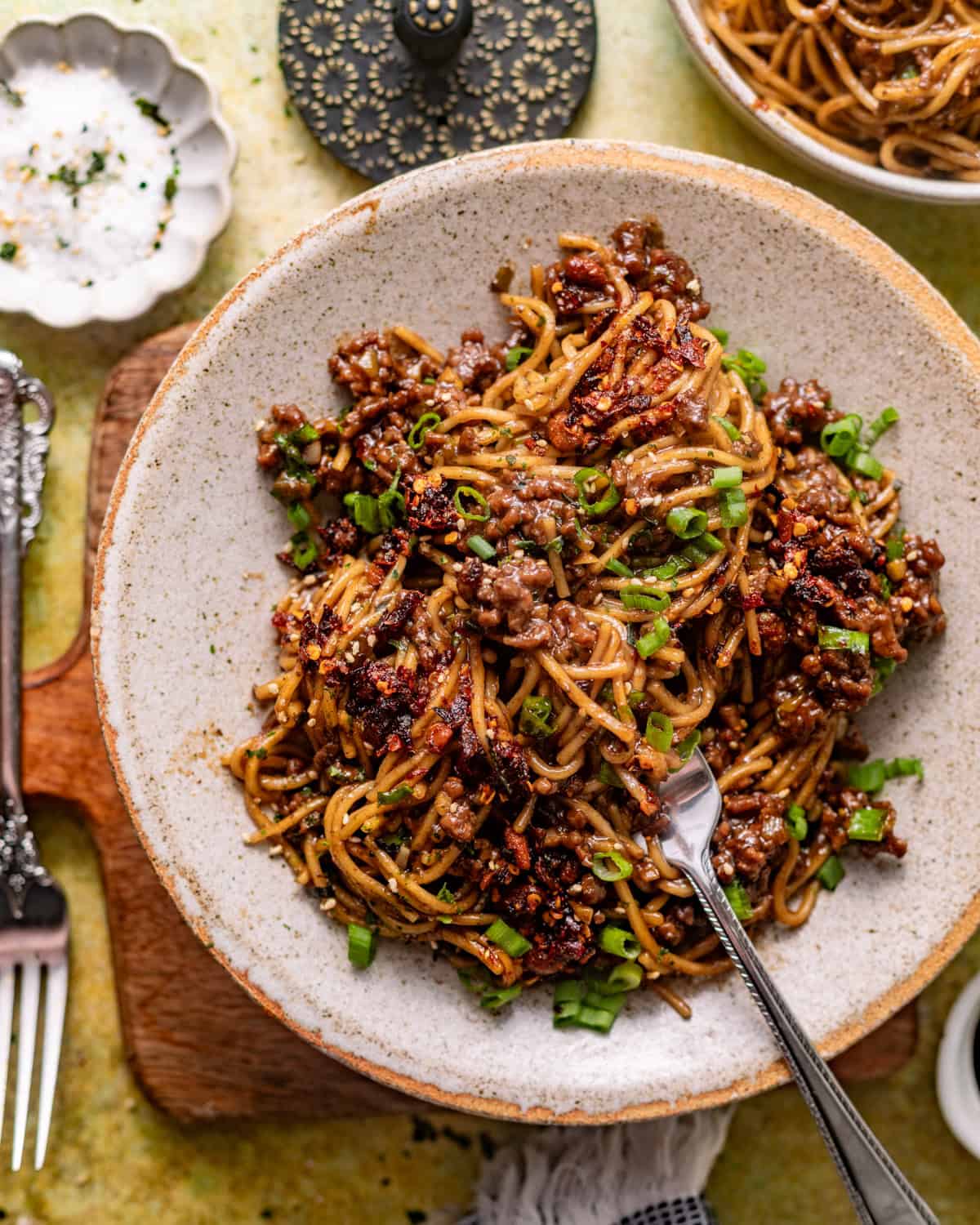 overhead photo of mongolian ground beef noodles in a bowl with a fork. 