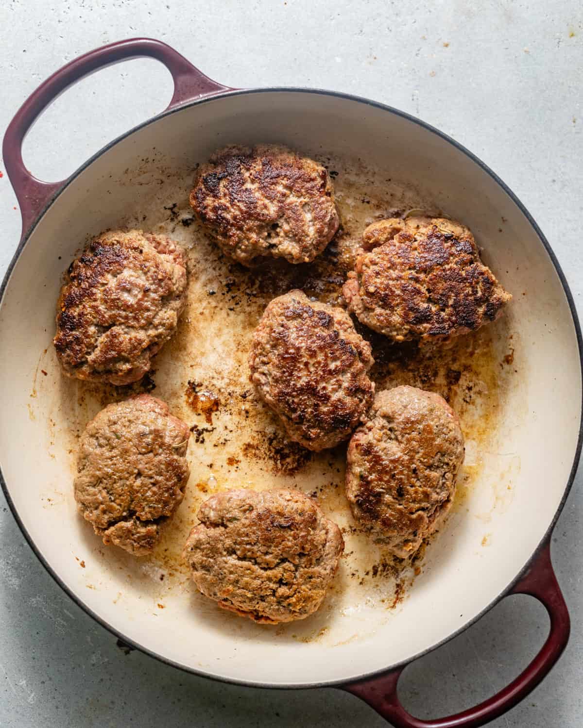 seared hamburger steaks in a pan. 