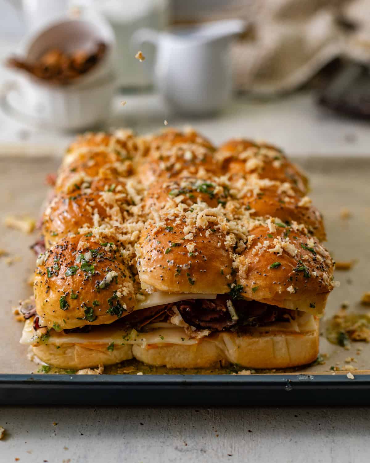 reuben sliders assembled on a baking sheet with french onions on top. 