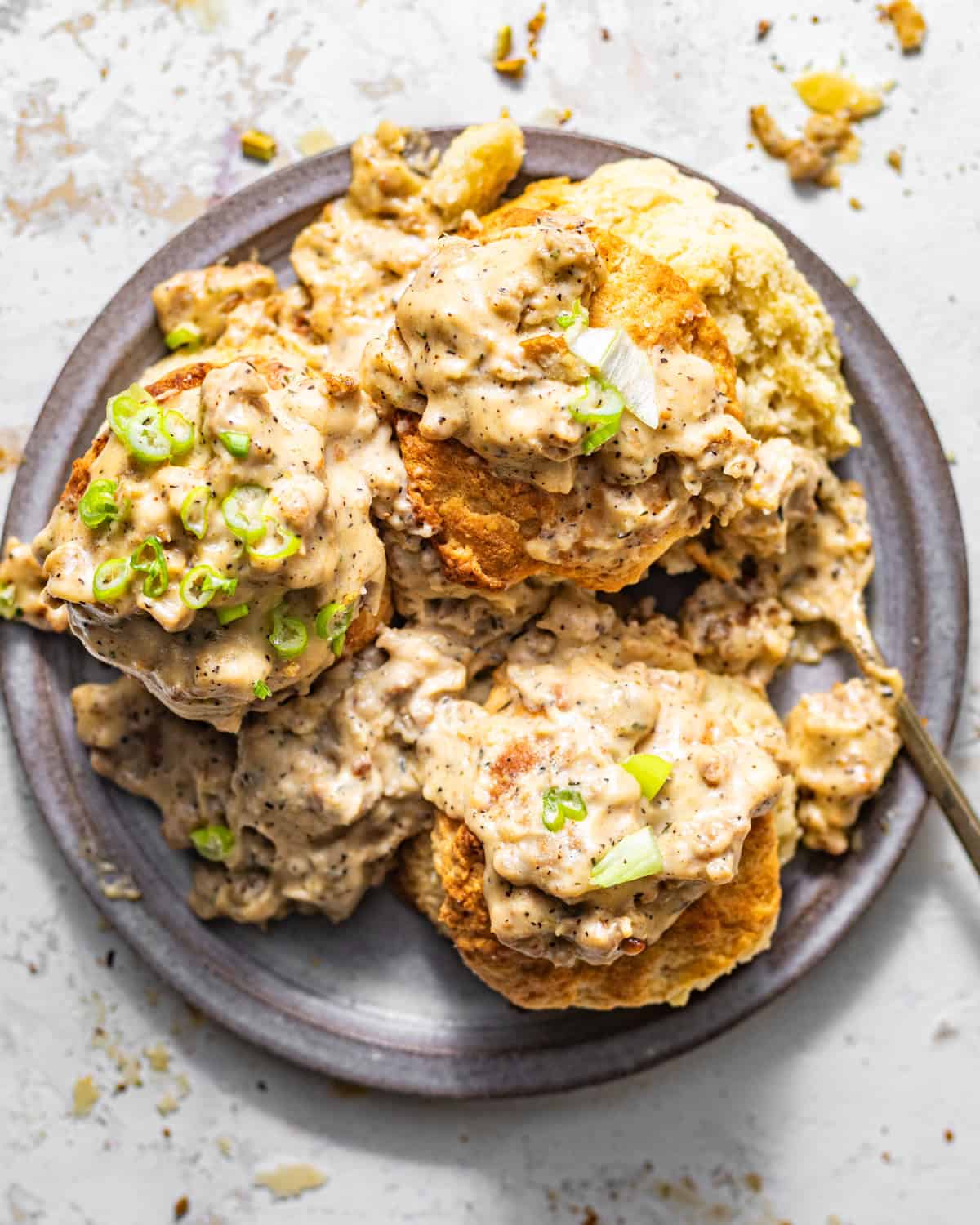 overhead photo of biscuits and gravy on a plate with a fork. 