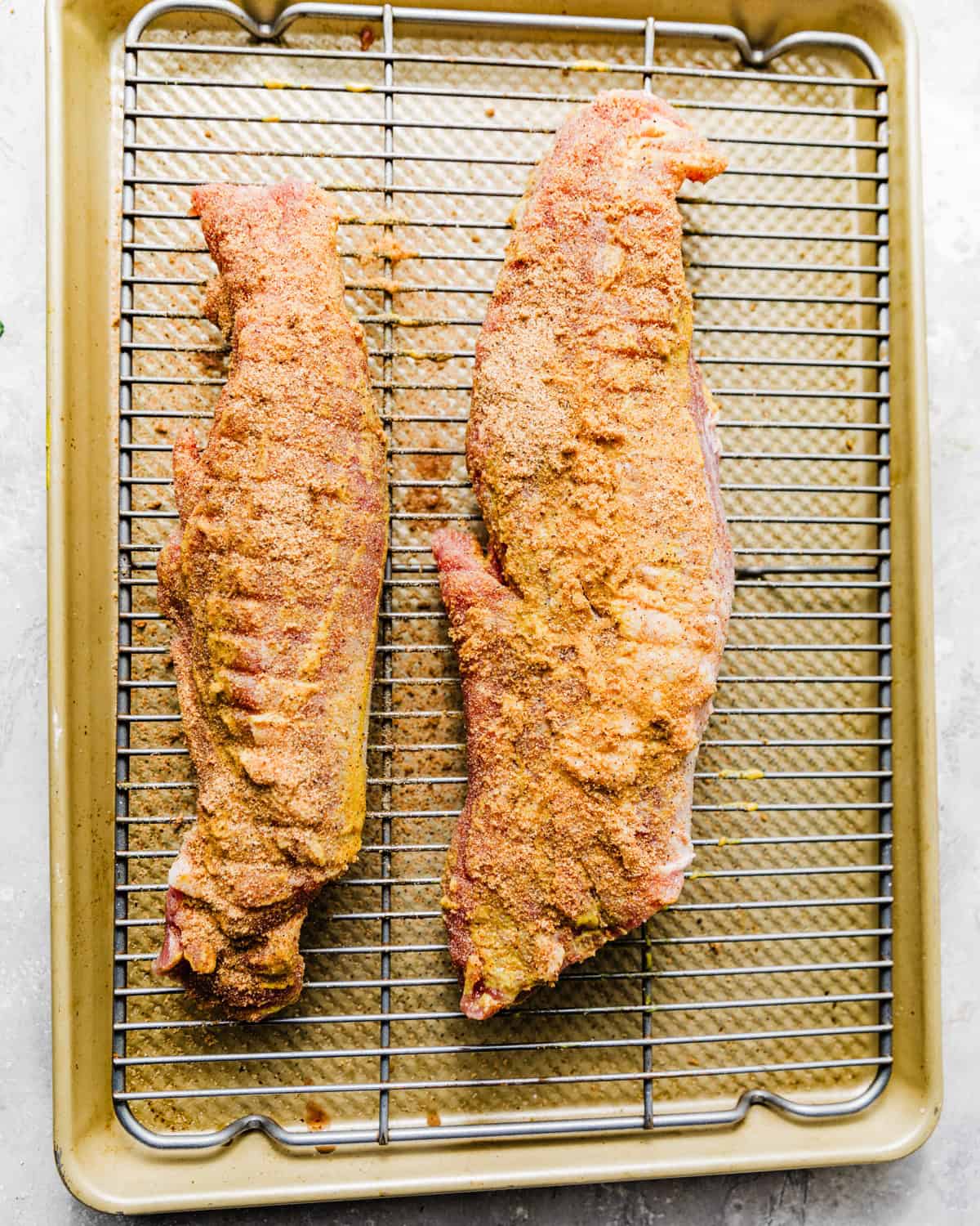 pork tenderloin on a wire rack coated in seasonings.