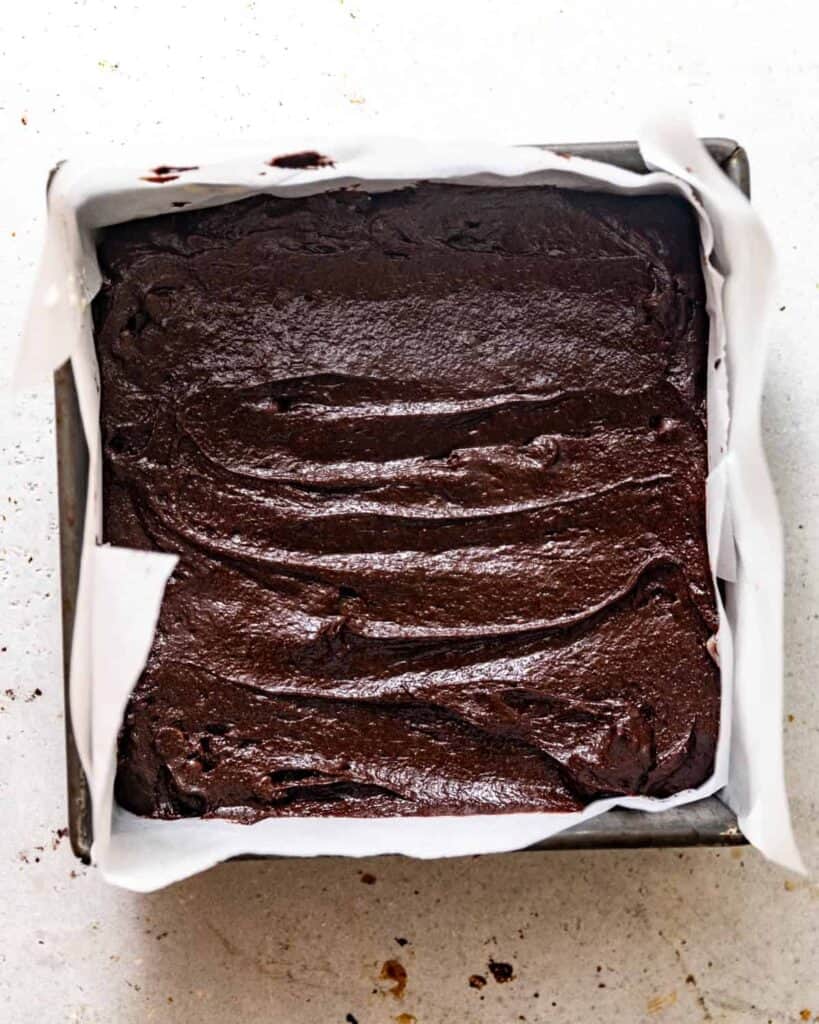 chocolate snack cake batter in a square baking dish. 