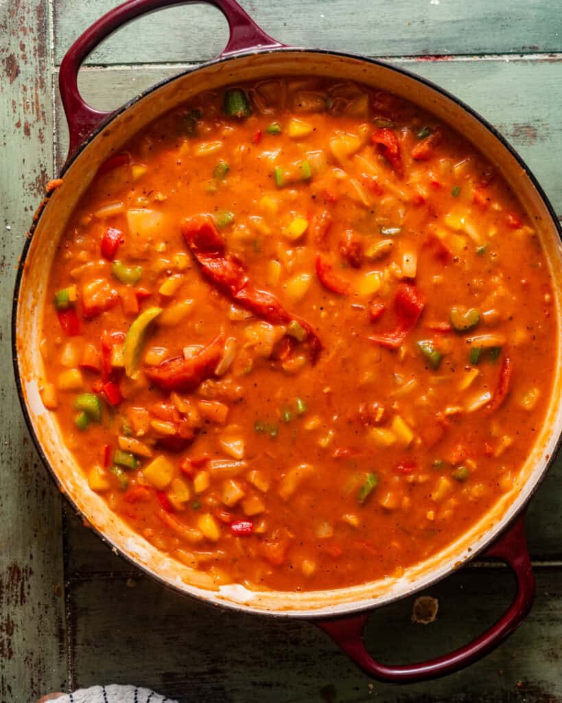 stewed tomatoes and seafood broth added into the pot to simmer until it begins to thicken. 