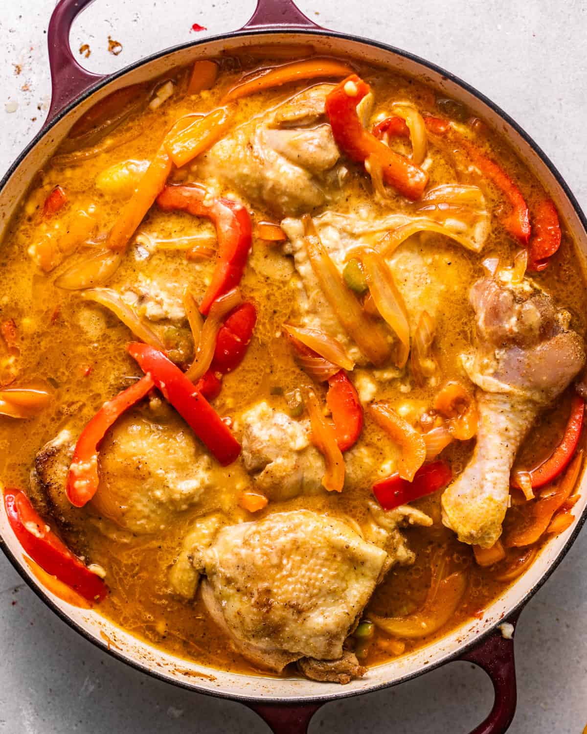 chicken legs and thighs in a pot with sauteed vegetables, chicken broth, cream of chicken soup, and bay leaves. 