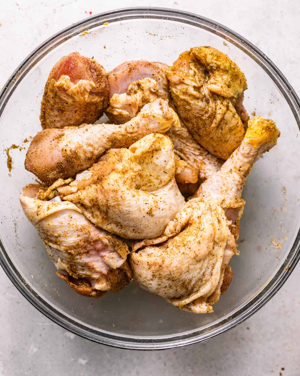 seasoned chicken legs and thighs in a bowl.