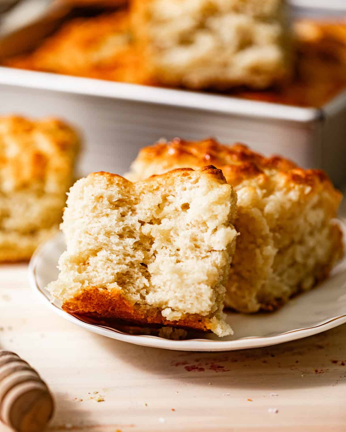 butter swim biscuits on a small plate cut in half to see the fluffy inside.