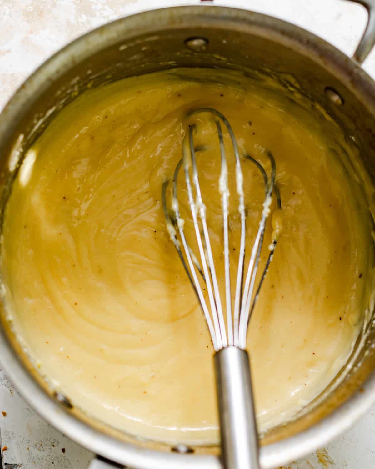 vanilla bean pastry cream in a saucepan with a whisk.
