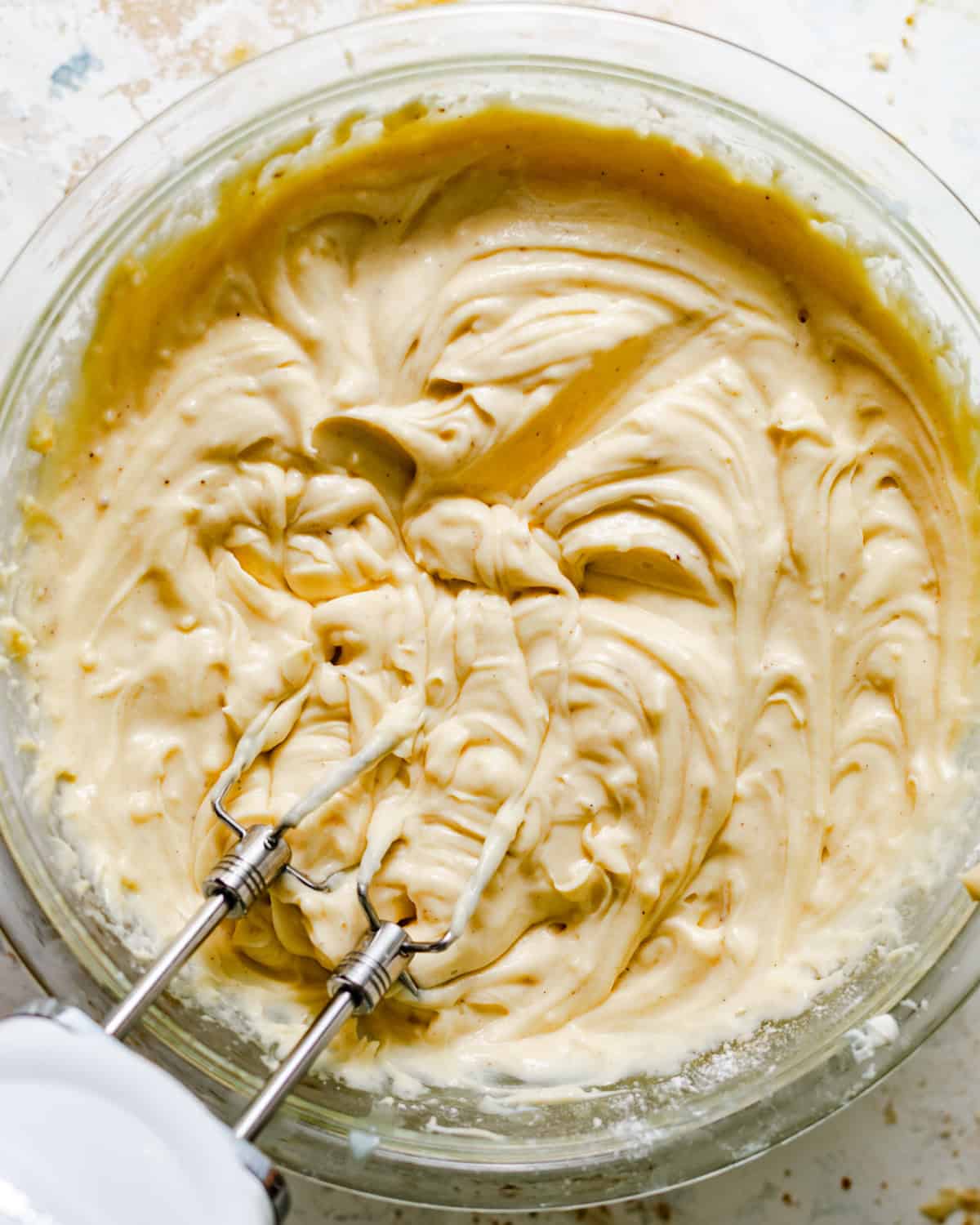 mascarpone pastry cream mixed together in a bowl with a hand mixer.