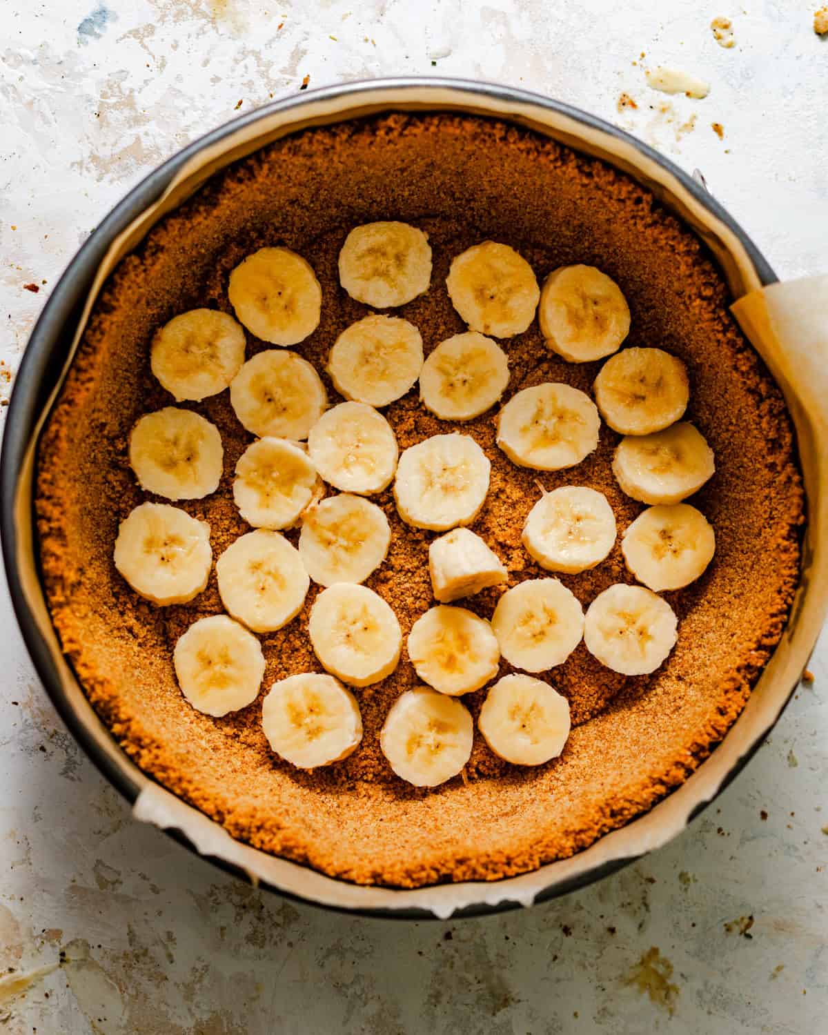 fresh sliced bananas placed on top of the brown butter graham cracker crust.