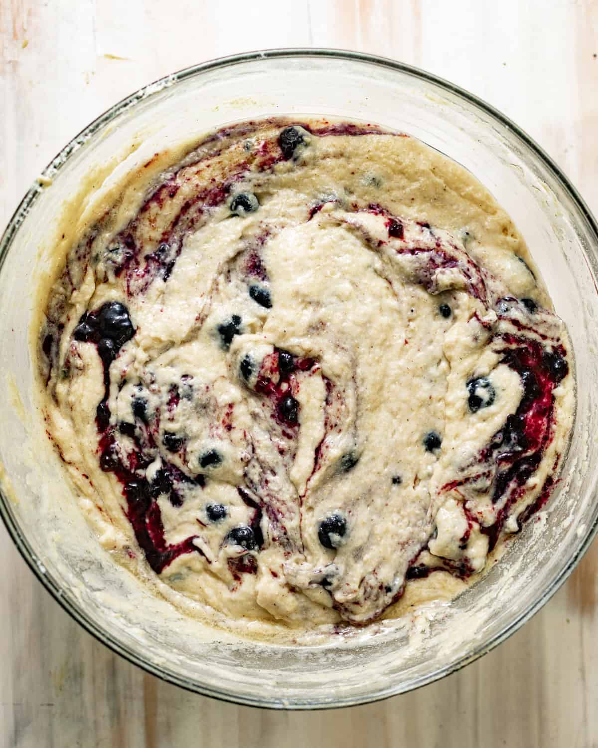 blueberry cornbread batter with blueberry preserves dolloped and swirled into the batter.