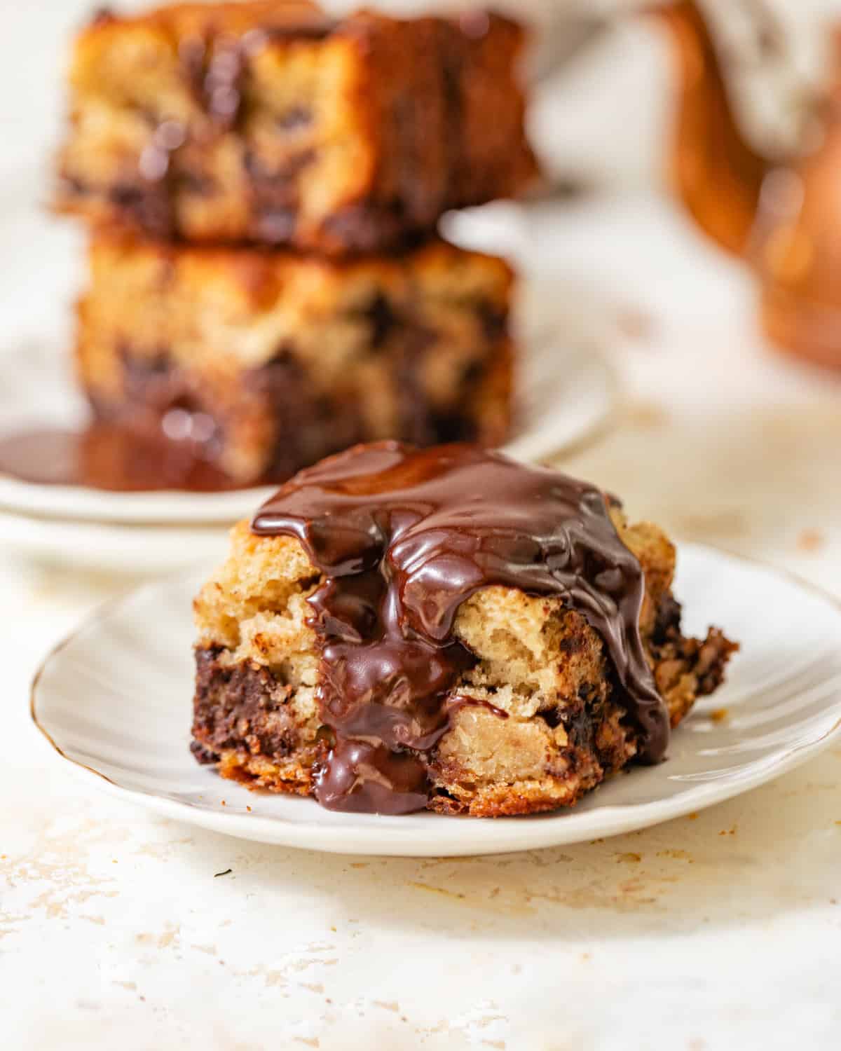 chocolate chip biscuit on a small plate with chocolate glaze drizzled on top. 