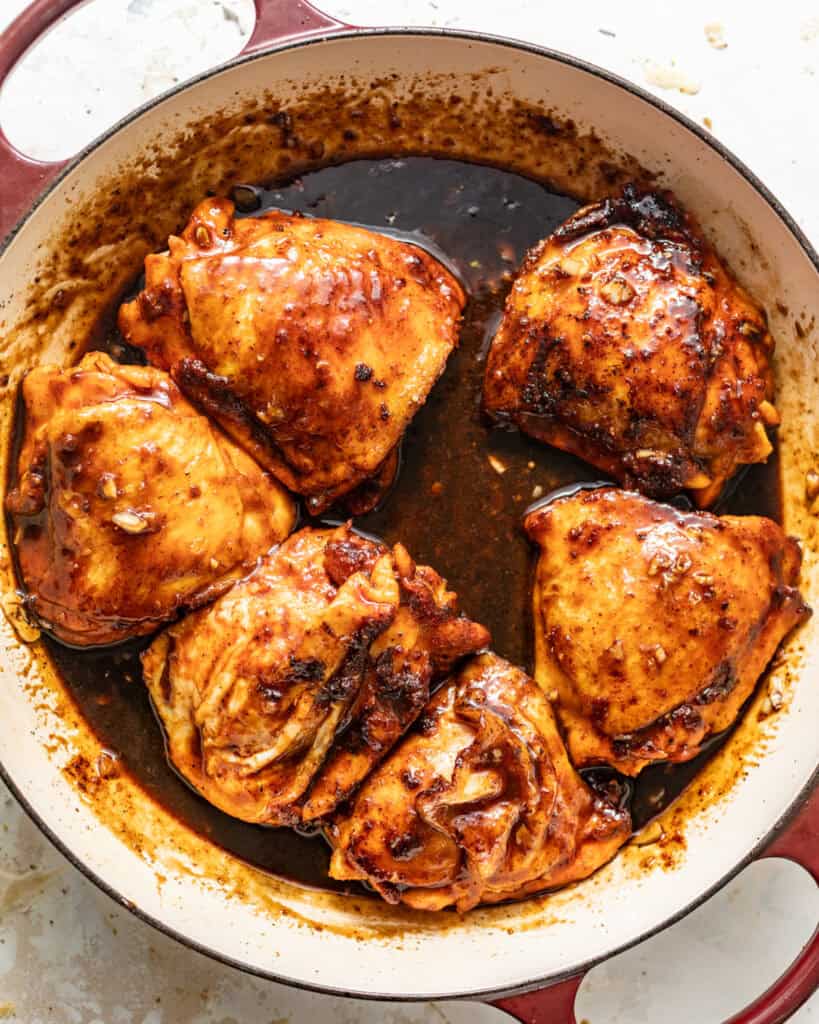 seared chicken coated in the honey garlic sauce in a skillet.