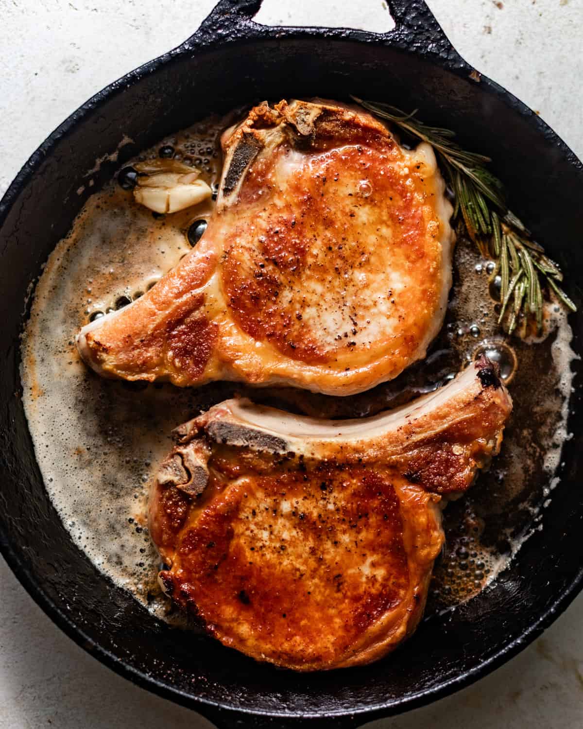 seared pork chops in a cast iron skillet.