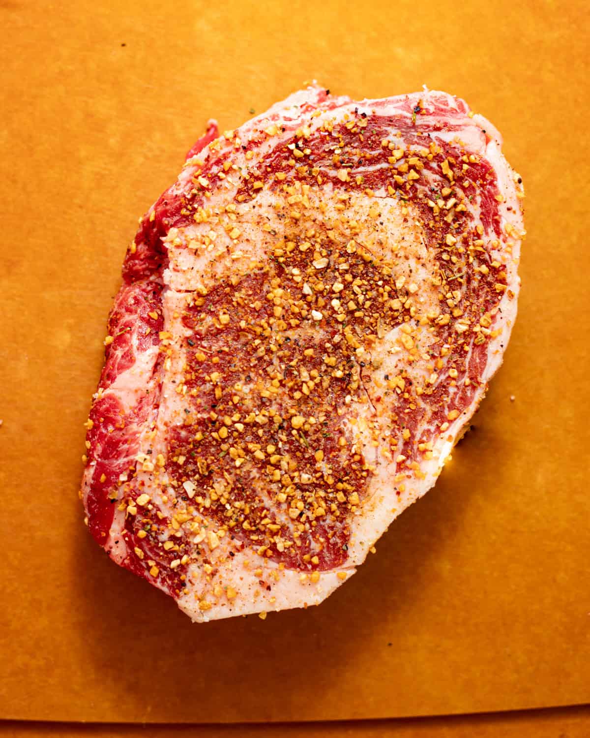 seasoned ribeye on a cutting board.