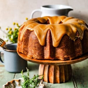 peanut butter pound cake on a cake stand topped with peanut butter fudge frosting.