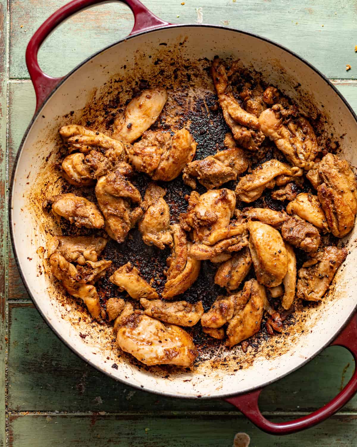 seared marinated jerk chicken in a skillet.