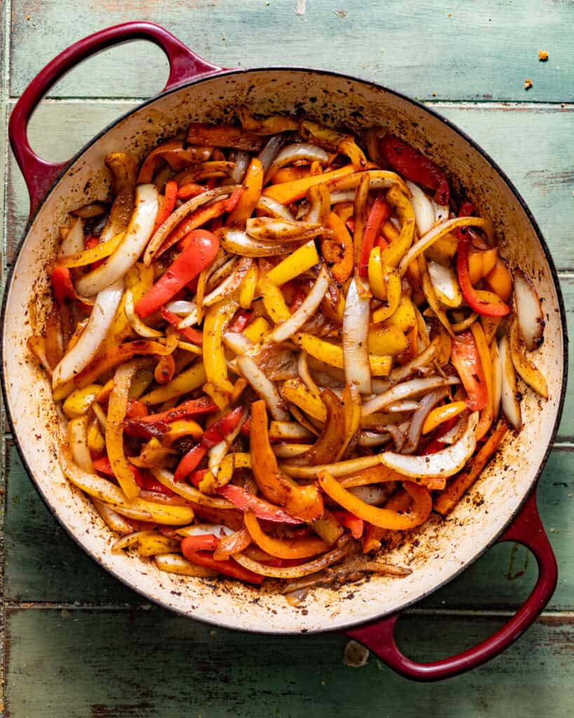 sauteed peppers and onions in a skillet.
