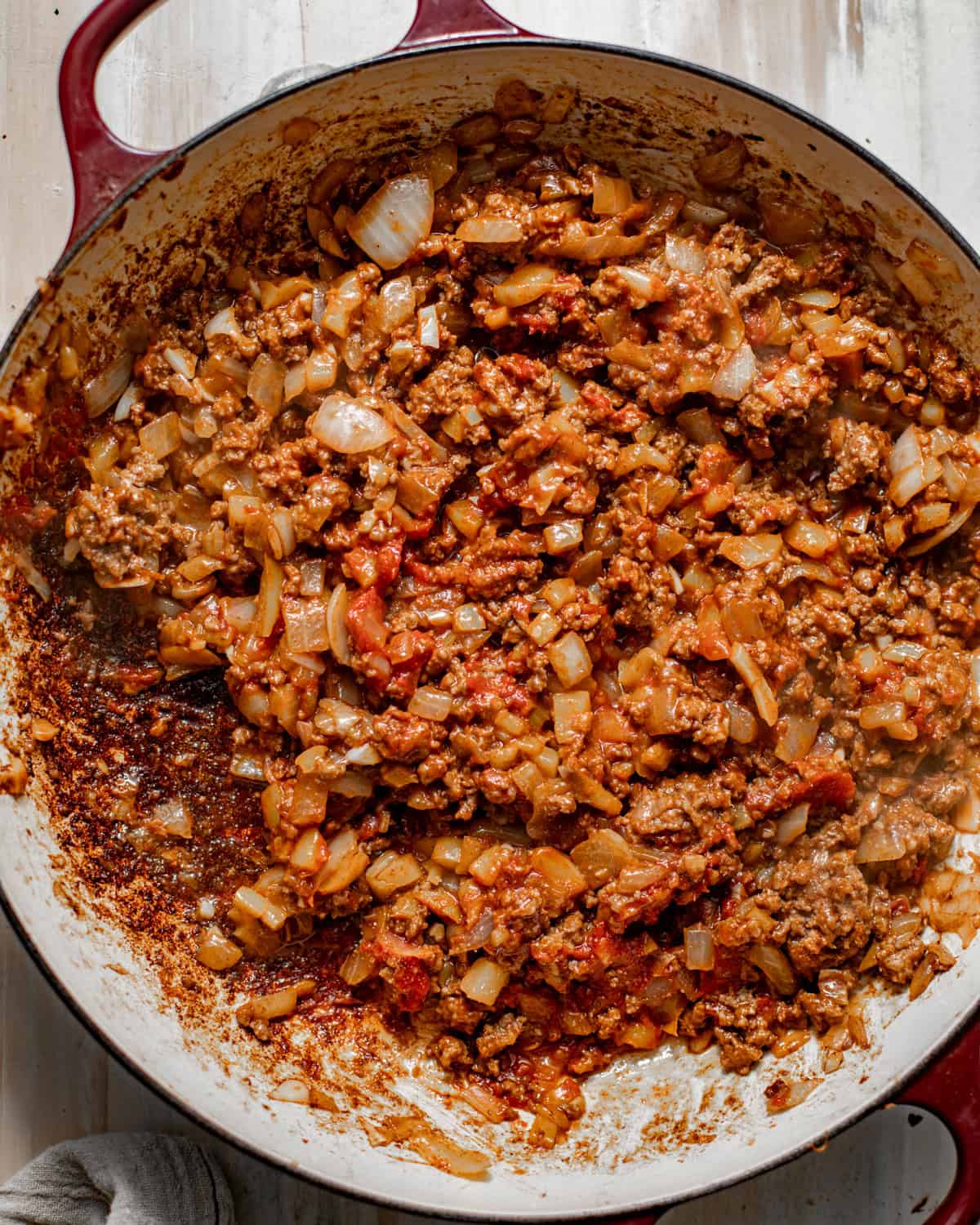 ground beef, onions, bell peppers, seasonings, and garlic all cooked in a large skillet.