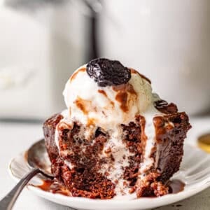 chocolate sticky toffee pudding on a small plate with a spoon.