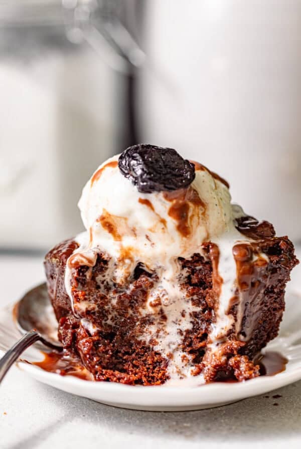 chocolate sticky toffee pudding on a small plate with a spoon.