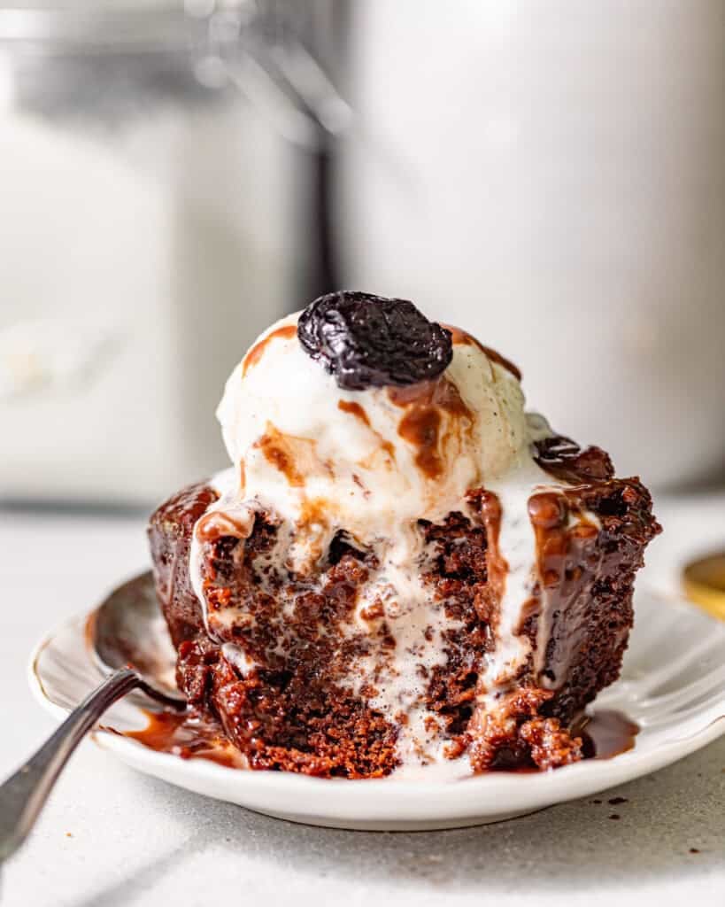 chocolate sticky toffee pudding on a small plate with a spoon.