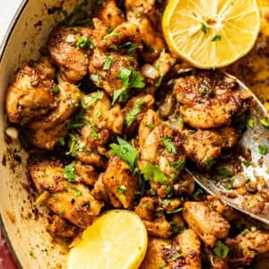 a serving spoon scooping the garlic butter chicken bites in the pan.