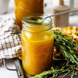 chicken broth in a mason jar with a spoon on top of the jar.