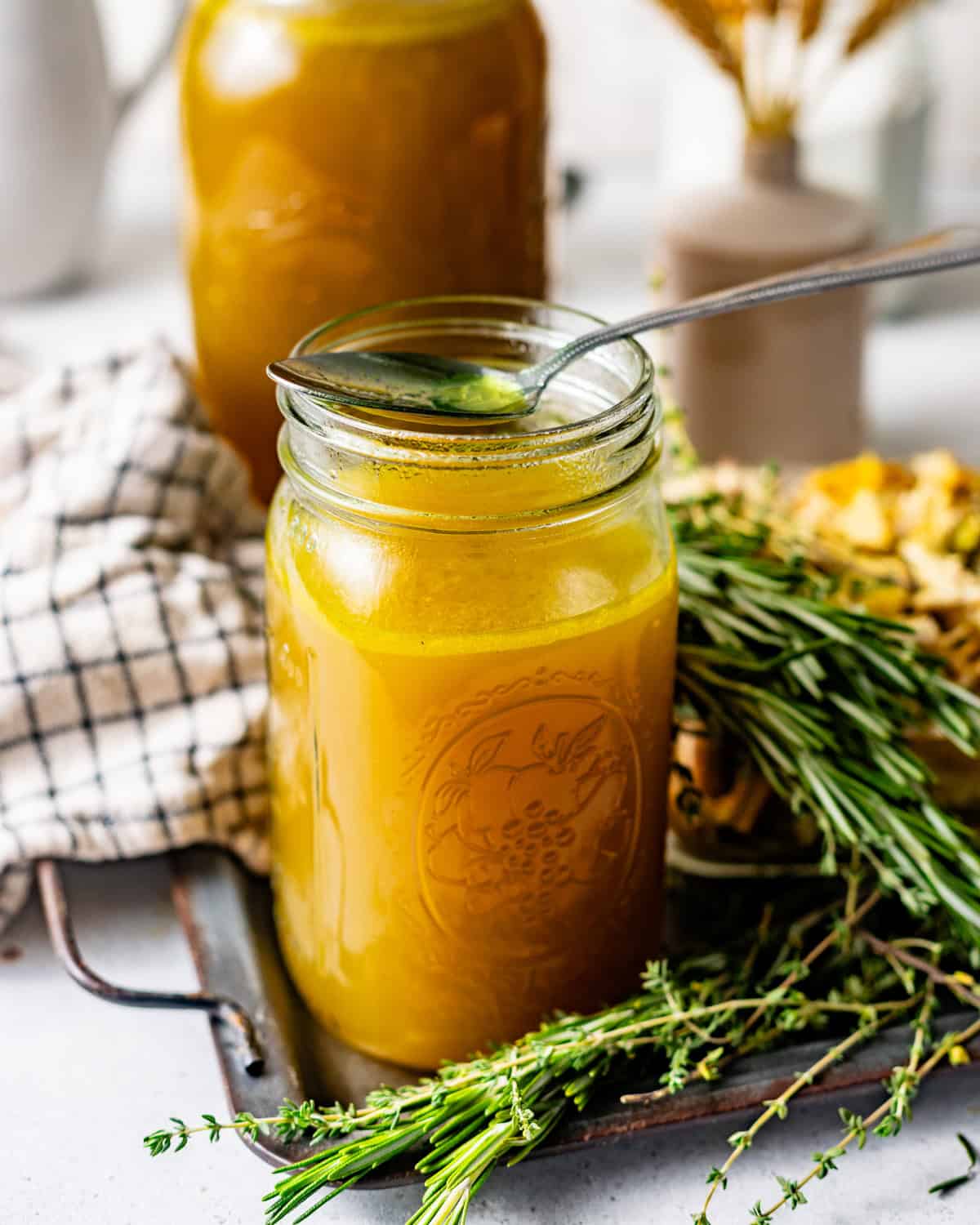 chicken broth in a mason jar with a spoon on top of the jar.