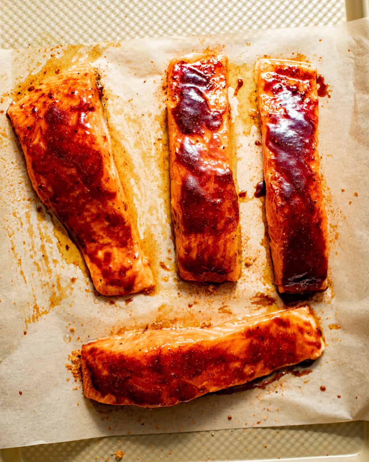 salmon on a baking sheet topped with the bbq sauce glaze.