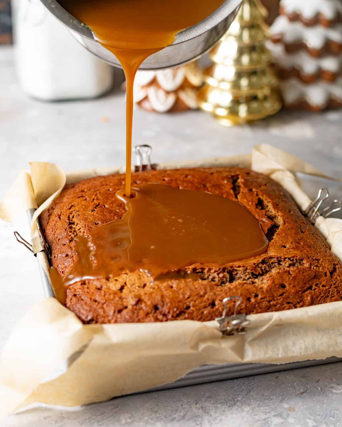 chocolate toffee sauce being poured on top of the warm chocolate sticky toffee pudding.