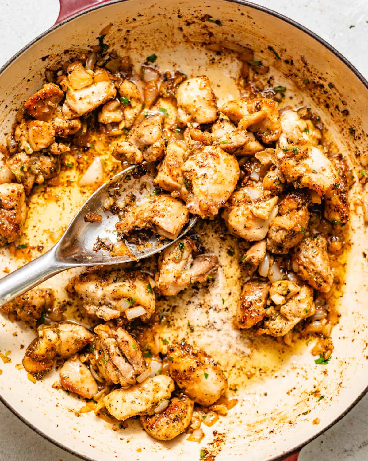 chicken bites tossed in garlic butter sauce in a skillet.