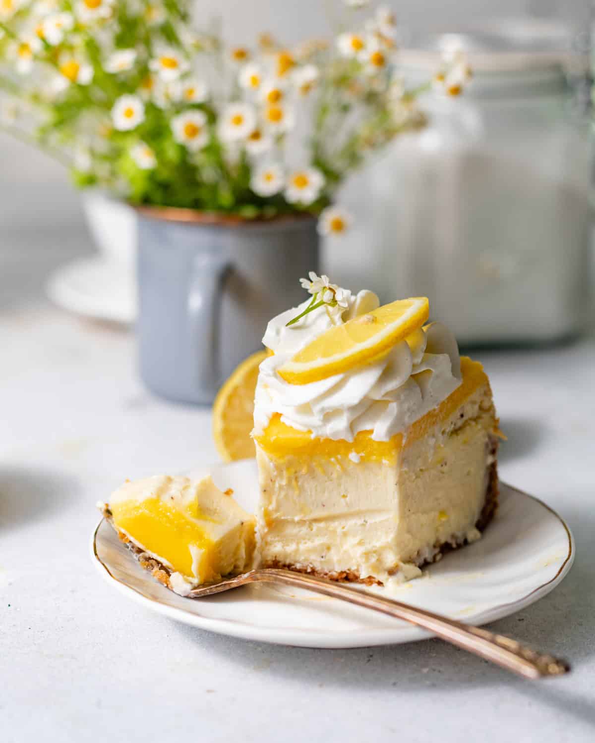 a slice of lemon cheesecake on a plate with a fork.
