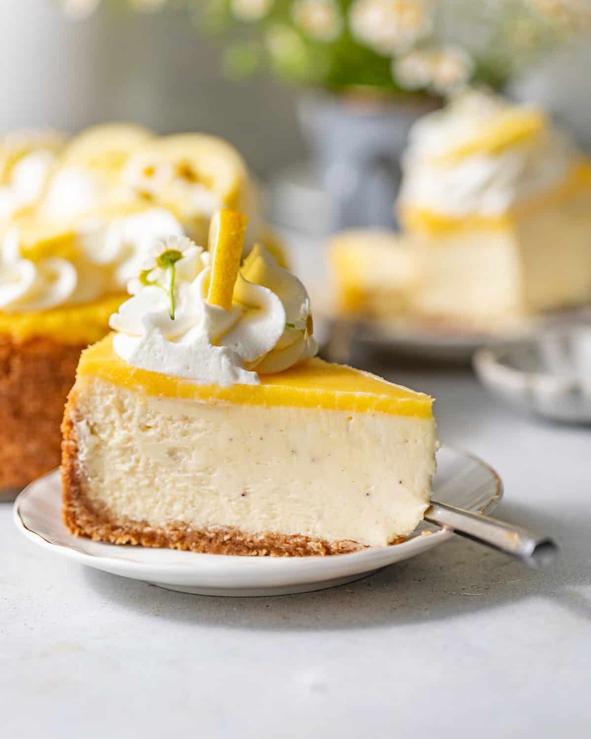 a slice of lemon cheesecake on a small cake plate.