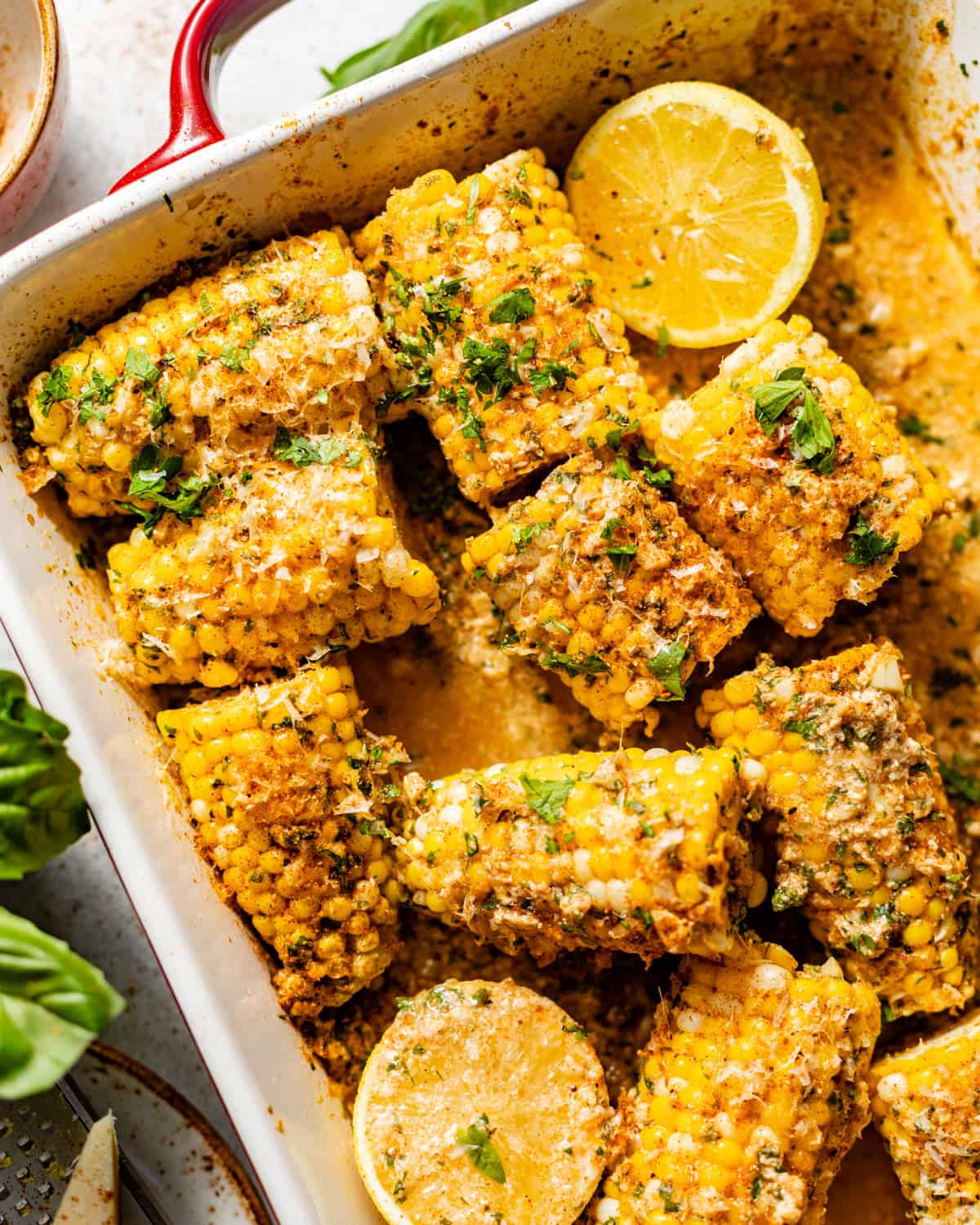 corn in a baking dish covered in garlic butter.