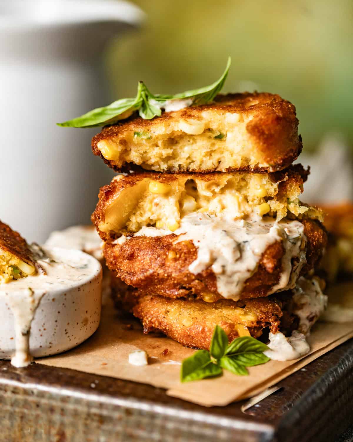 corn fritters stacked on top of each other on a serving tray.