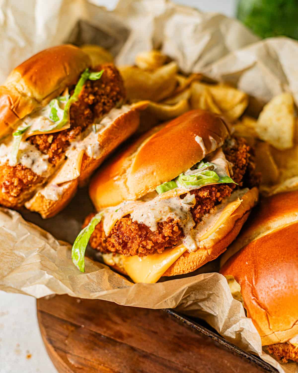 fried fish sandwiches in a serving tray stacked on top of each other.