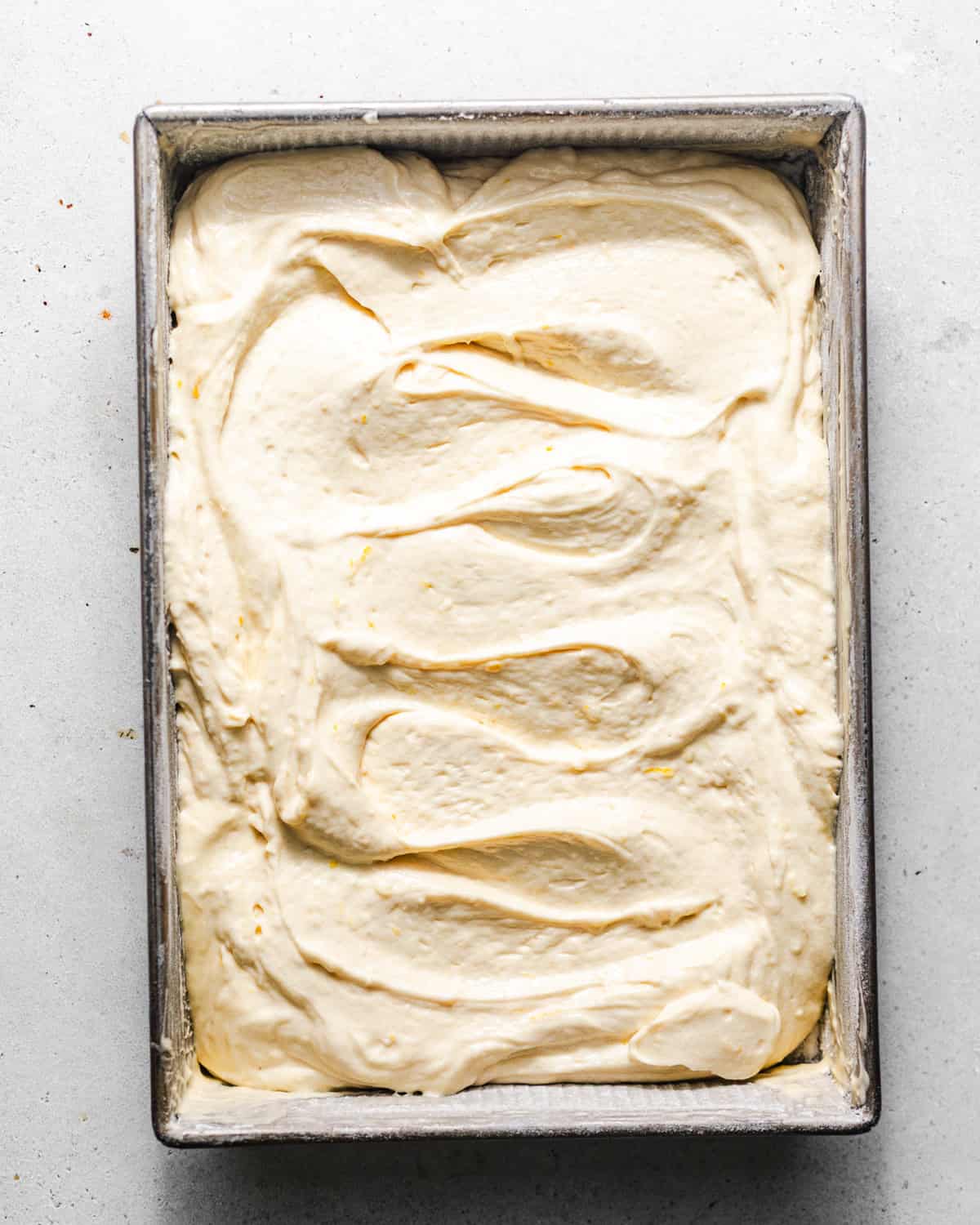 lemon cake batter added to a 9 by 13 baking dish.