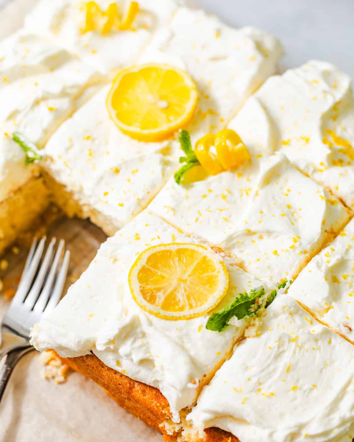 lemon sheet cake on a serving tray with forks.