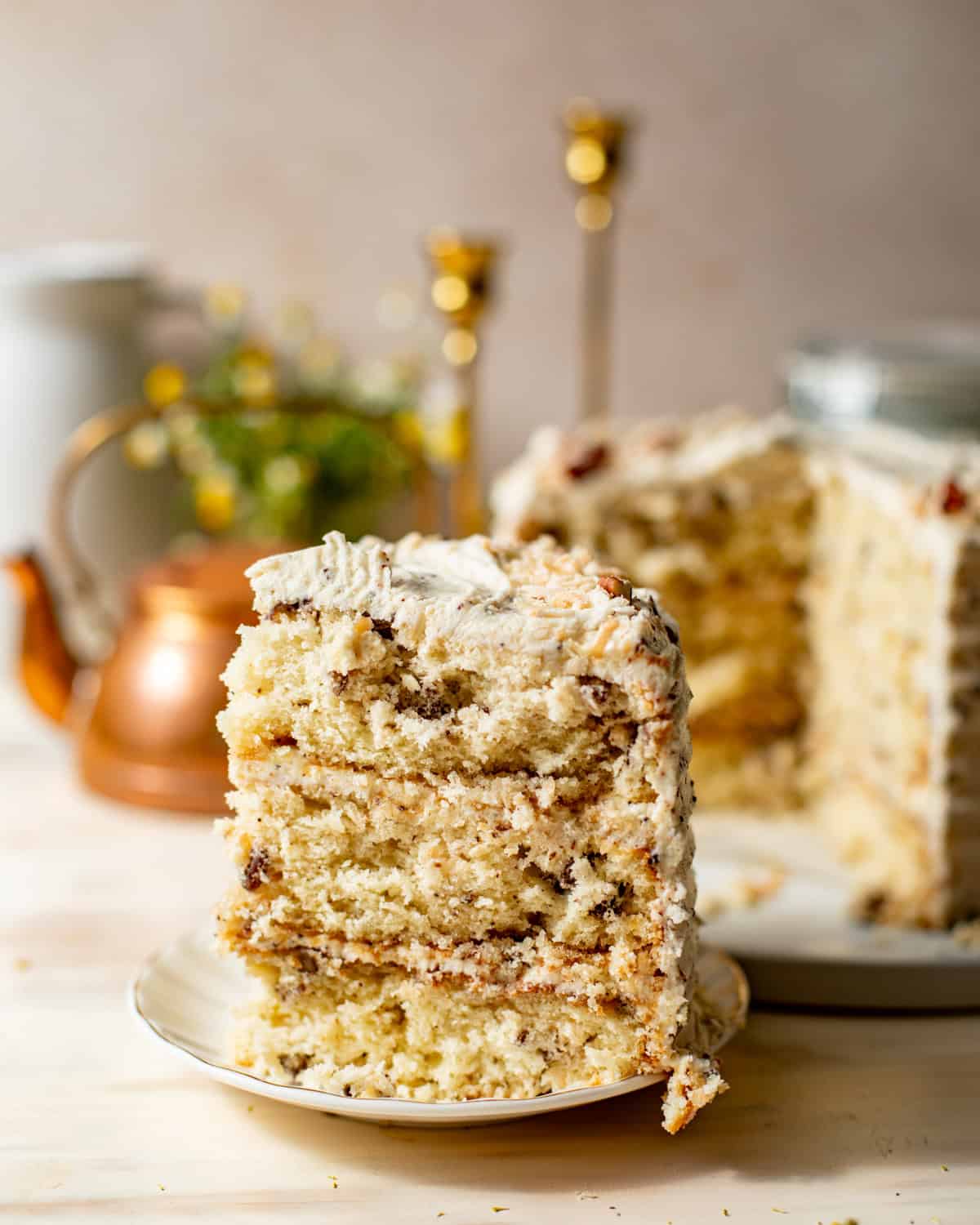 Slice of Italian cream cake with pecans, coconut, and brown butter cream cheese frosting.