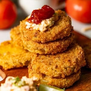 fried green tomatoes stacked on top of one another with pimento cheese on top.