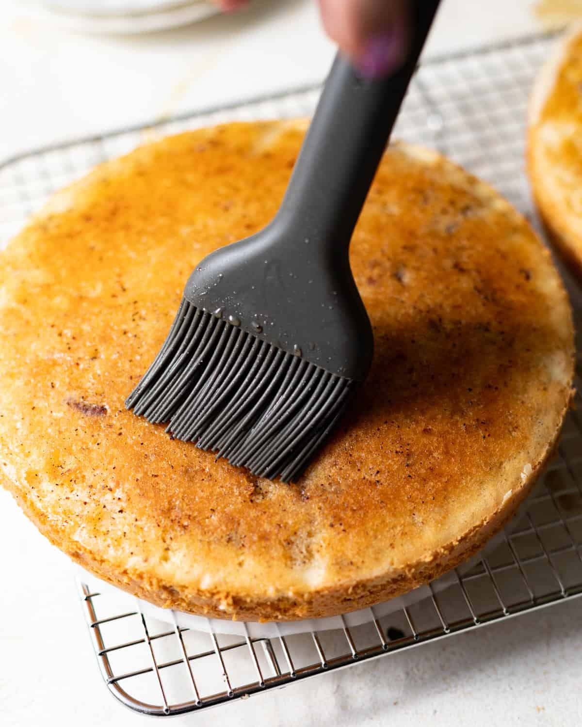 Vanilla bean simple syrup brushed over a warm Italian cream cake layer.