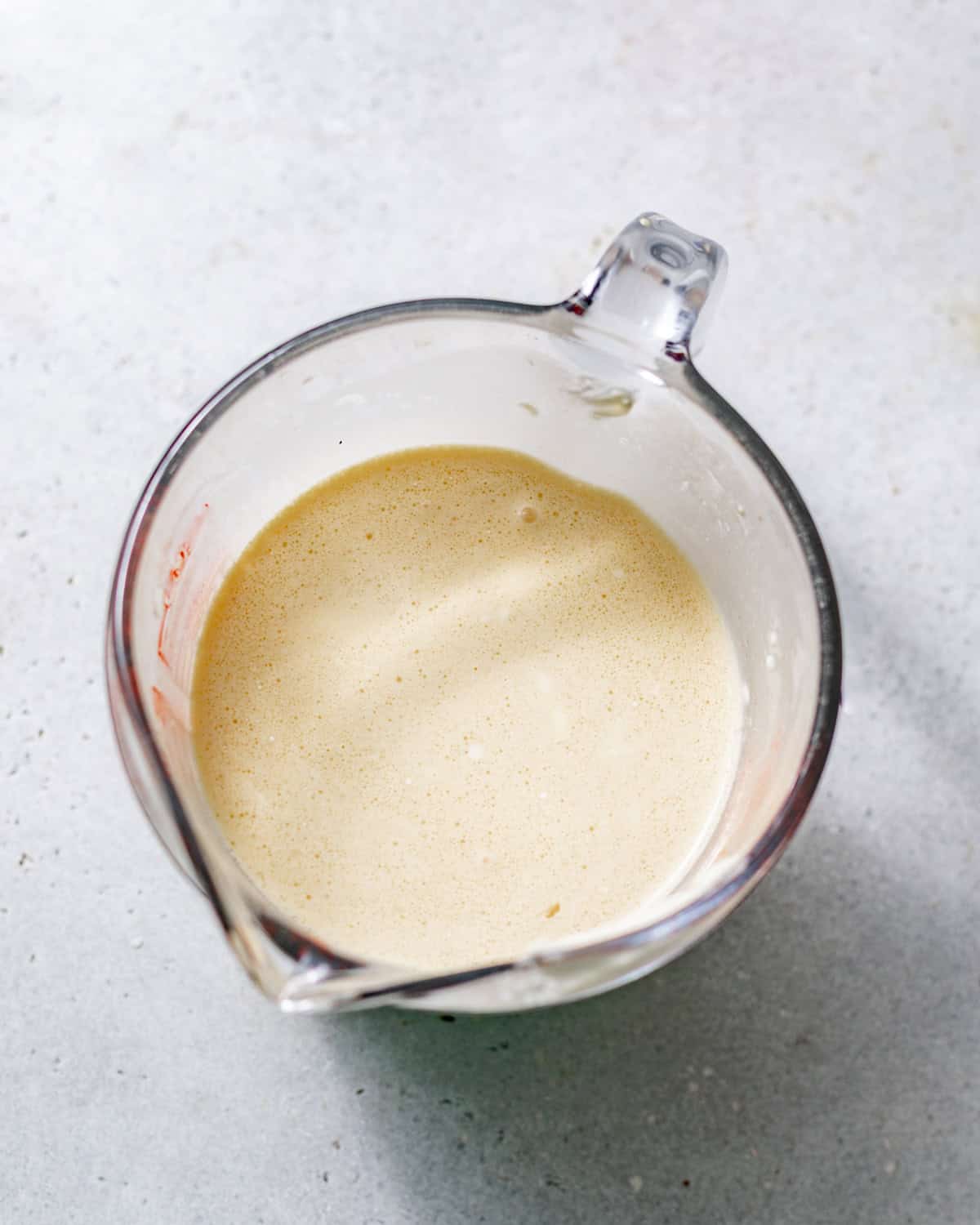 milk cake soak mixed together in a small glass measuring cup.