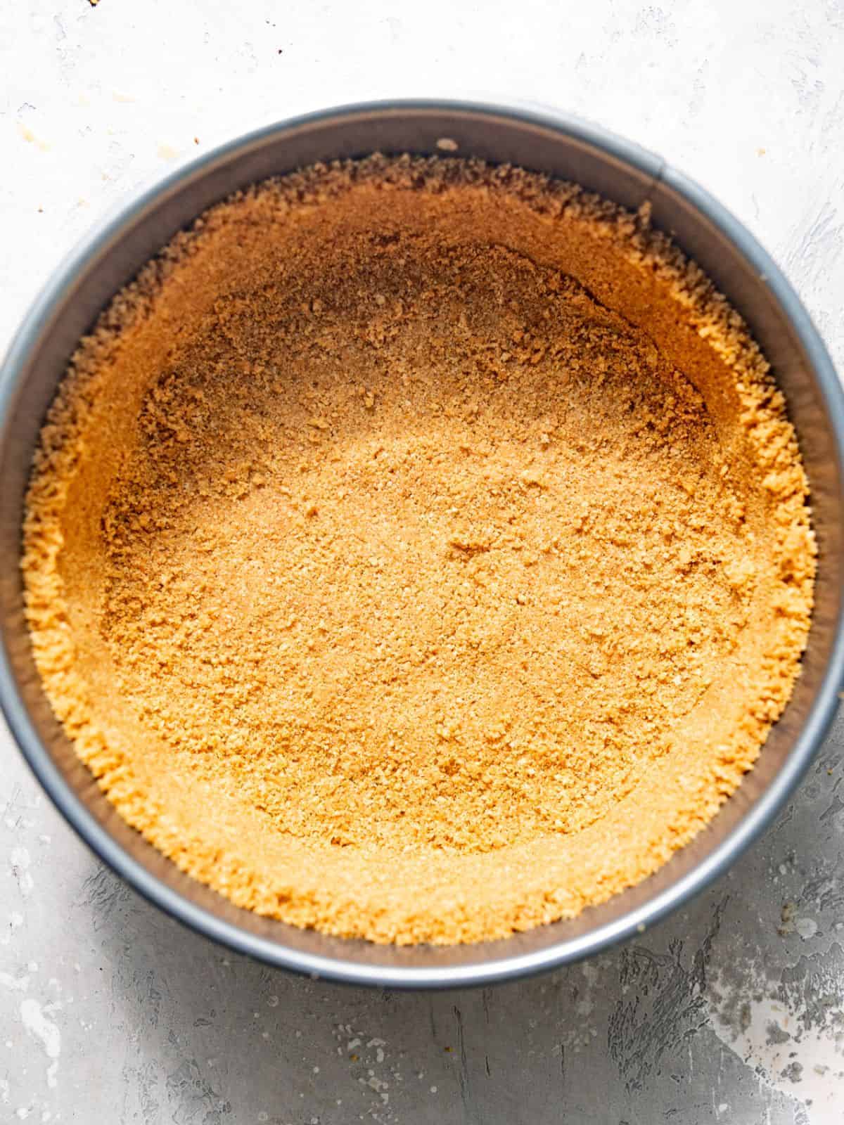graham cracker crust in a parchment paper lined springform pan.