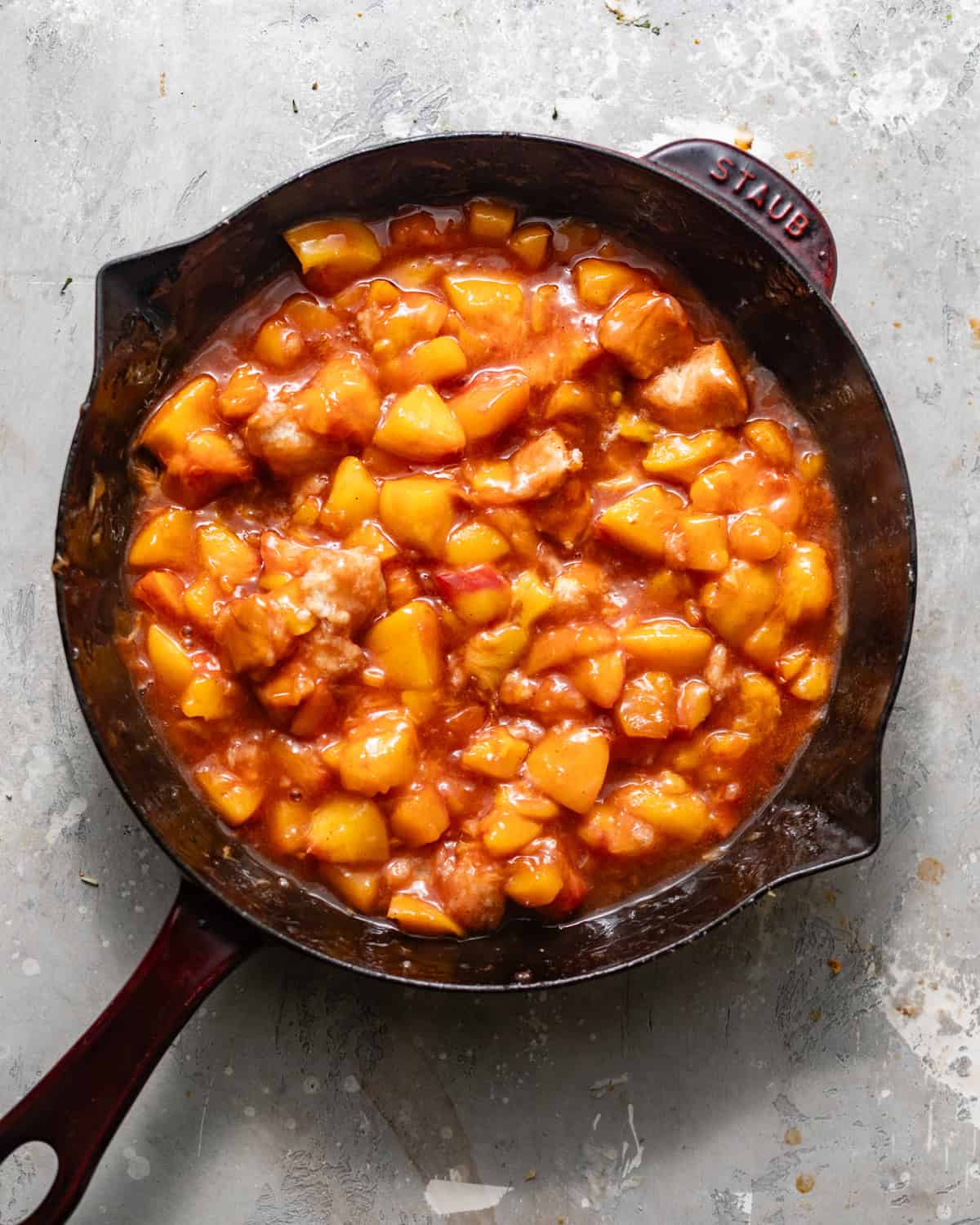 peach cobbler filling cooked in a skillet.