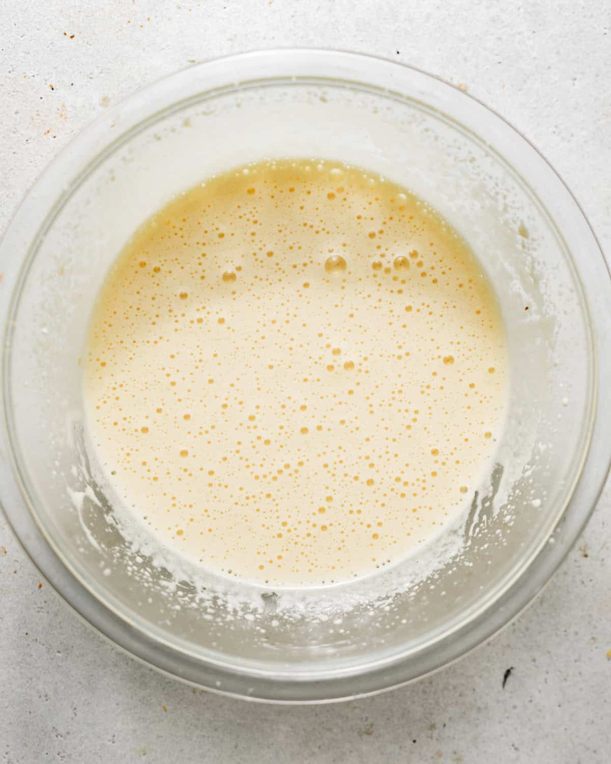 egg yolks, sugar, vanilla extract, and milk mixed together in a bowl.