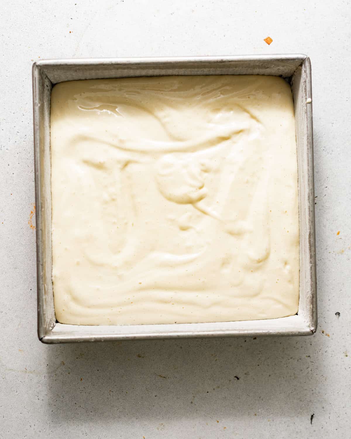 tres leches cake batter in a square baking pan.