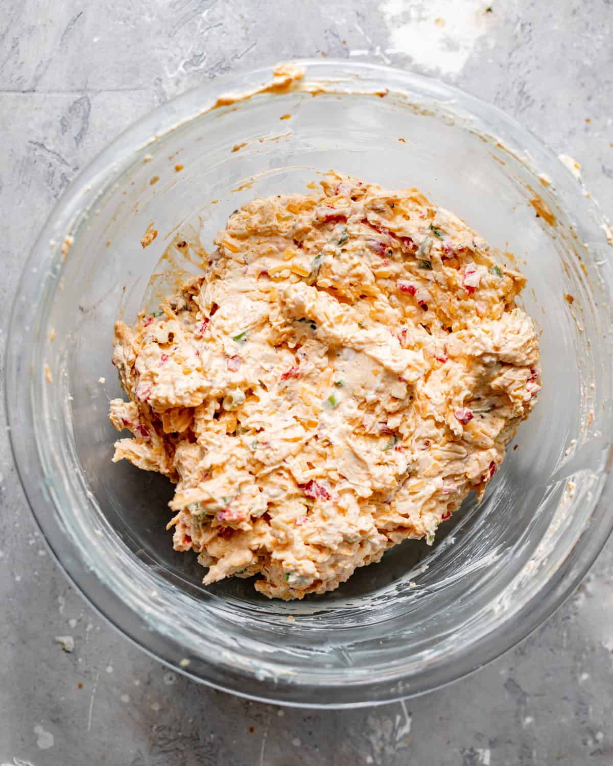 pimento cheese ingredients mixed together in a mixing bowl before chilling in the refrigerator.